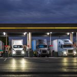 A semi truck fueling alone at a truck stop at night, symbolizing the financial pressure and fuel volatility facing trucking companies in today’s freight market.